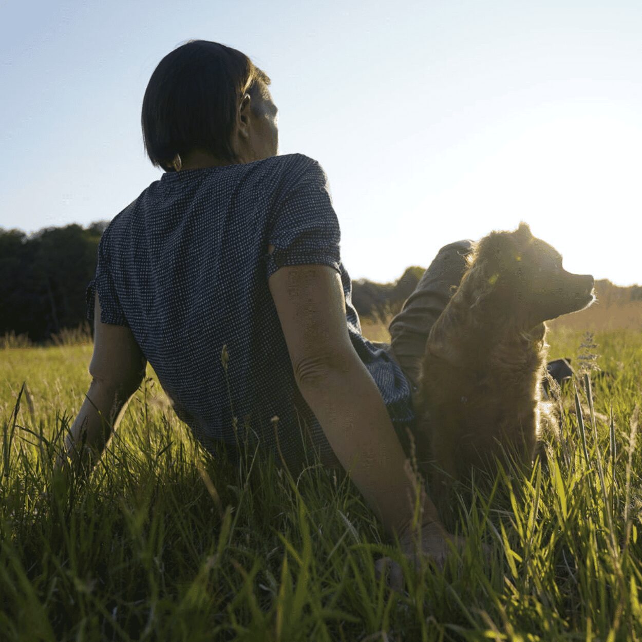 Claudia Ostwald mit Hund Mikosch auf einer Wiese